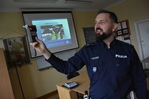 Zdjęcie przedstawia policjanta prezentującego sprzęt policyjny