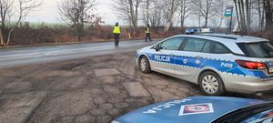 Zdjęcie przedstawia policyjne radiowozy oraz policjantów podczas kontroli trzeźwości kierujących