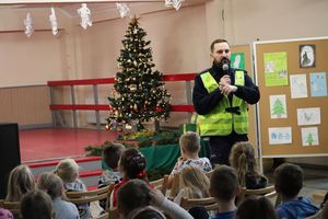 Zdjęcie przedstawia policjanta ruchu drogowego podczas pogadanki w szkole