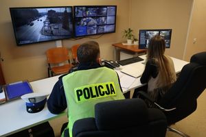 Zdjęcie przedstawia policjanta oraz operatora monitoringu miejskiego w pomieszczeniu