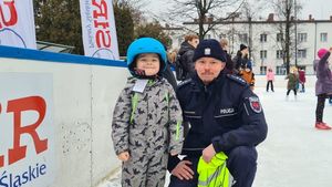 Zdjęcie przedstawia policjanta z dzieckiem