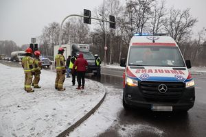 Zdjęcie przedstawia ambulans pogotowia ratunkowego oraz policjantów i strażaków zabezpieczających miejsce wypadku drogowego