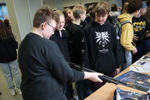 Zdjęcie przedstawia młodzież podczas oglądania broni służbowej na dniach otwartych szkoły