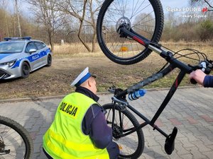 Zdjęcie przedstawia policjanta kontrolującego rowerzystę