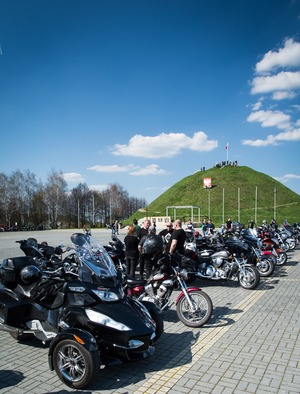 Zdjęcie przedstawia motocykle ustawione na tle Kopca Wyzwolenia