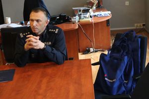 Zdjęcie przedstawia szefa piekarskich policjantów siedzącego przy stole