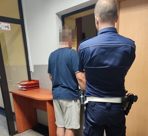 Zdjęcie policjanta oraz mężczyzny, który poddawany jest badaniu na zawartość alkoholu