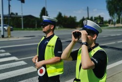 Umundurowani policjanci podczas nadzoru nad ruchem w rejonie przejścia dla pieszych