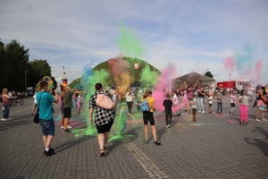 Zdjęcie przedstawia wyrzut kolorów holi oraz uczestników imprezy