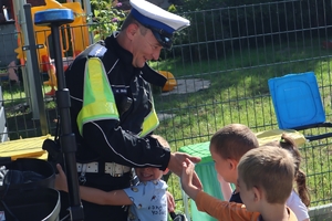 Zdjęcie przedstawia policjanta i dzieci przy policyjnym motocyklu