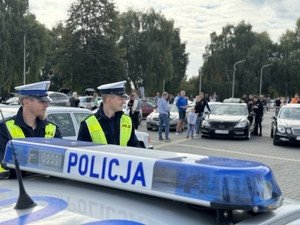 Zdjęcie przedstawia radiowóz oraz policjantów