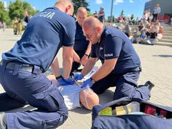 Zdjęcie przedstawia policjantów ćwiczących udzielanie pierwszej pomocy na fantomie