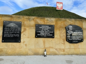 Zdjęcie przedstawia pamiątkowe tablice znajdujące się przed Kopcem Wyzwolenia