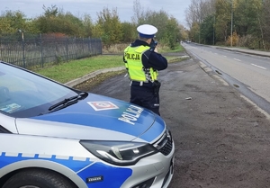 Zdjęcie przedstawia policjanta kontrolującego prędkość