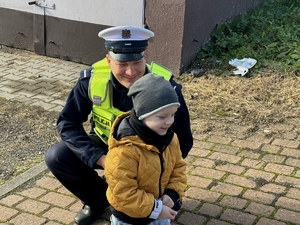 Zdjęcie przedstawia policjanta oraz chłopczyka