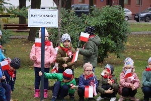 Zdjęcie przedstawia dzieci przy posadzonym drzewie