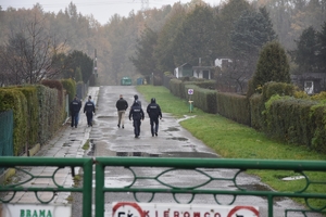 Zdjęcie przedstawia idących w oddali policjantów