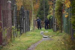 Zdjęcie przedstawia idących w oddali policjantów