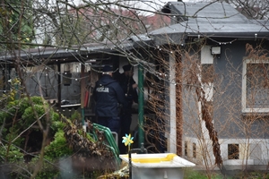 Zdjęcie przedstawia policjantów podczas rozmowy z właścicielem ogródka działkowego