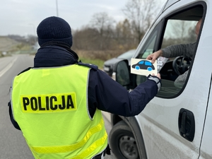 Zdjęcie przedstawia policjanta przy samochodzie