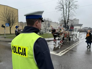 Zdjęcie przedstawia policjanta zabezpieczającego przemarsz na skrzyżowaniu