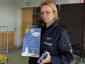 Zdjęcie przedstawia policjantkę trzymająca w ręku plakat