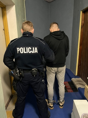 Zdjęcie policjanta trzymającego zatrzymanego mężczyznę