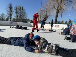 Dzieci leża na lodzie, ćwiczą udzielanie pomocy