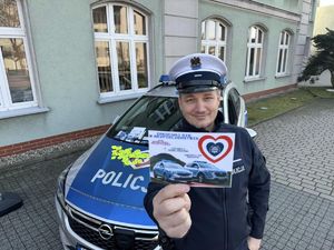 Zdjęcie przedstawia policjanta z ulotką