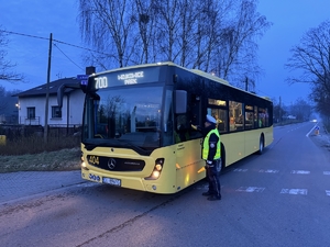 Zdjęcie przedstawia policjanta badającego trzeźwość kierującego autobusem