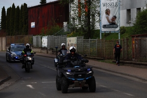 Zdjęcie przedstawia policyjne motocykle oraz czterokołowiec podczas przejazdu