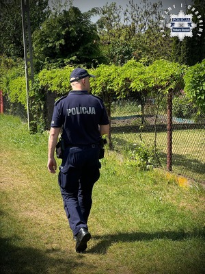 Zdjęcie przedstawia policjanta podczas kontroli ogródków działkowych