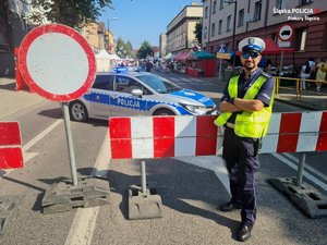 Zdjęcie przedstawia policjanta zabezpieczającego ulicę