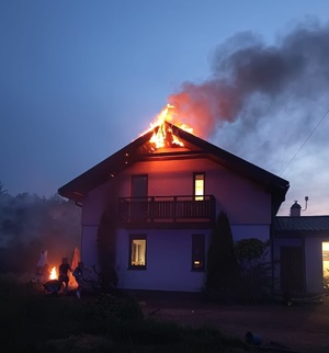 Zdjęcie przedstawia palący się dach domu jednorodzinnego