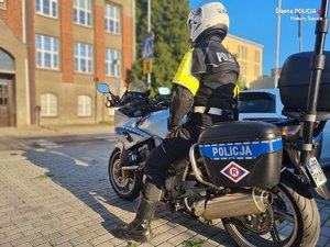 Zdjęcie policjanta na motocyklu przy szkole