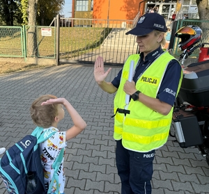 Zdjęcie przedstawia policjantów oraz dzieci podczas drogi do szkoły.