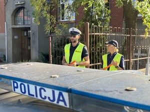 Zdjęcie przedstawia policjantów oraz dzieci podczas drogi do szkoły.