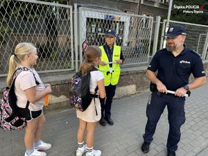 Zdjęcie policjantów podczas rozmowy z dziećmi przed szkołą