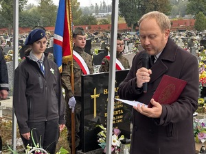 Mężczyzna przemawia przed grobem