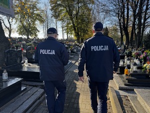 Zdjęcie policjantów idących po cmentarzu