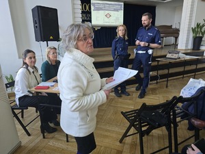 Zdjęcie policjanta oraz uczestników spotkania