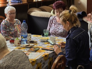 Zdjęcie policjantów i seniorów podczas wizyty w klubie seniora