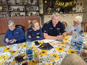 Zdjęcie policjantów i seniorów podczas wizyty w klubie seniora
