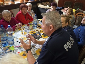 Zdjęcie policjantów i seniorów podczas wizyty w klubie seniora