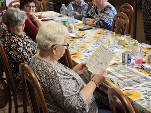 Zdjęcie policjantów i seniorów podczas wizyty w klubie seniora
