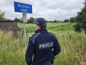 Zdjęcie policjanta podczas kontroli rzeki oraz zbiornika wodnego