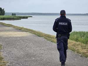 Zdjęcie policjanta podczas kontroli rzeki oraz zbiornika wodnego