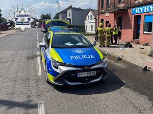 Zdjęcie policyjnego radiowozu na miejscy wypadku drogowego