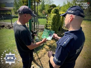 Zdjęcie dzielnicowego podczas kontroli ogródków działkowych
