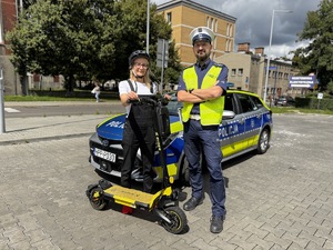 Zdjęcie policjanta wraz z kierującą hulajnogą elektryczną